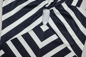 Detail of black and white striped satin dress showing twisted front and cutout design