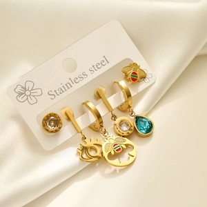 Detailed set of gold stainless steel earrings with bee and evil eye charms on silk