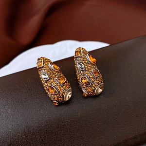 Vue macro de boucles d'oreilles vintage géométriques avec des cristaux ambrés
