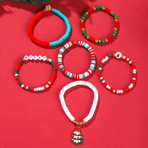 Close-up of set of six Christmas beaded bracelets with festive charms on red background