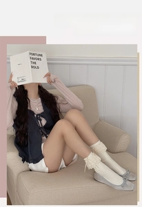 Detail of cream lace socks featuring delicate ruffle edges and sweet bow accents
