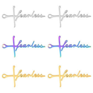 Macro detail of fearless engraved cross pendants in silver, gold, and rainbow finishes