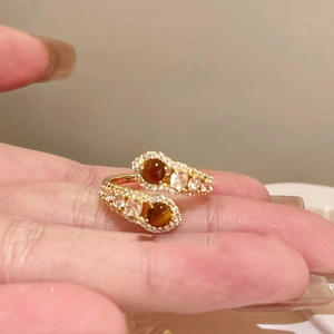 Detailed view of 18K gold plated ring featuring brown tiger eye stones and cubic zirconia