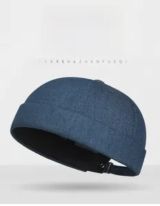 Detail of blue denim skull cap showing twill texture and adjustable metal buckle