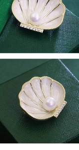 Macro detail of French vintage shell brooch with elegant pearl and zircon accents