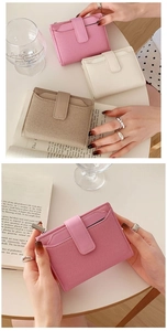 Three colors of short bifold wallets in pink, beige, and white with a textured leather finish