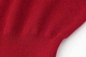Detailed macro view of dark red knit fabric texture and ribbed elastic edge finish