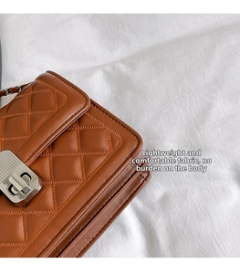 Detail of brown quilted faux leather bag with silver twist lock and chain strap
