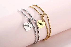 Detail view of heart pendants with MOM engraving in gold and silver stainless steel