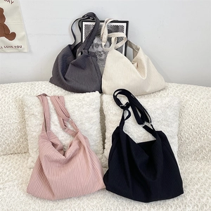 Detail of four pleated canvas crossbody bags in grey, white, pink, and black colors