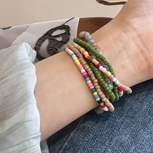 Detail shot of a seven-piece bohemian beaded bracelet set worn on a female wrist