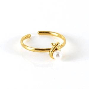 Macro shot of gold adjustable stainless steel ring with a single white pearl detail