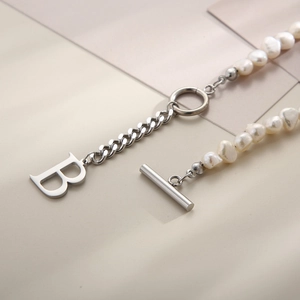 Detail of baroque pearl and silver chain necklace with letter B charm and OT buckle