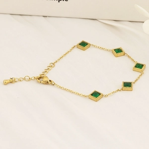 Macro shot of 18K gold plated titanium bracelet featuring square emerald cubic zirconia stones