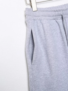 Détail d'un pantalon de jogging en maille gris clair avec cordon de serrage et poches