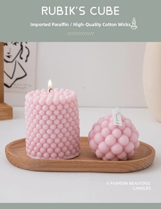 Macro shot of lit pink bubble geometric candles on a wooden tray for home decor