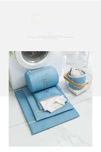 Detail view of light blue mesh laundry bags with zipper and embroidered garment icons