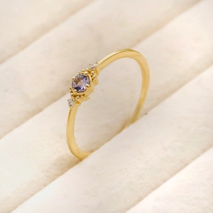 Close-up of a 925 silver tanzanite ring with a purple stone in a golden finish box
