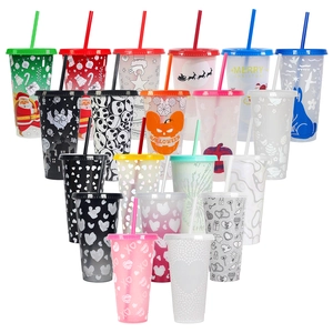 Close-up of assorted color-changing Christmas cups with festive patterns and straws