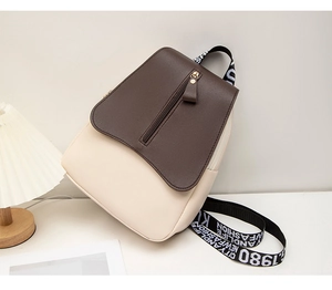 Detail view of the brown flap and white PU leather contrast of this stylish backpack