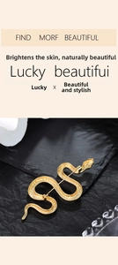 Detailed macro view of golden snake brooch with intricate scale texture on black background