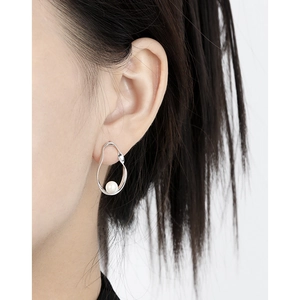 Minimalist S925 sterling silver stud earrings with oval pearls on model's ear
