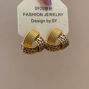 Close-up of S925 silver needle triangle earrings with brown leopard print and gold finish