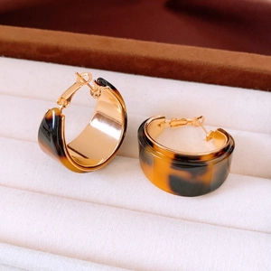 Macro shot of 18K gold plated hoop earring with elegant brown tortoiseshell resin texture