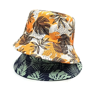 Double-sided bucket hat with tropical leaf prints in orange and navy blue finishes