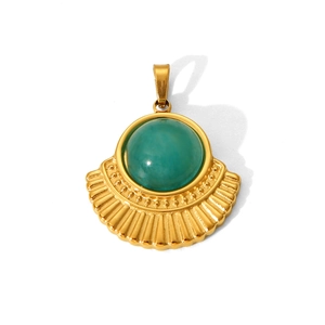 Macro detail of fan-shaped gold titanium steel pendant with inlaid green gemstone