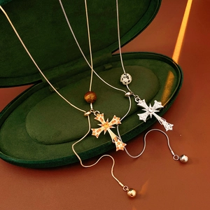 Detail shot of tiger eye cross pendants in gold and silver within a green velvet box
