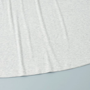 Detail shot of light gray knit fabric with high-quality double stitching on the hemline