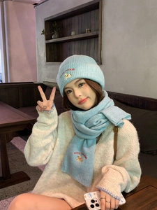 Detail of light blue knit hat and scarf set with cute lucky puppy embroidery