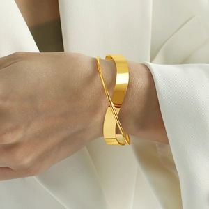 Minimalist irregular twisted gold open bangle with geometric polished metal design