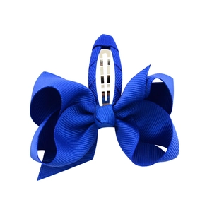 Detail of royal blue grosgrain ribbon bow hair clip with silver metal snap base