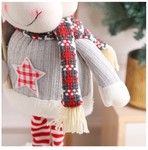 Detail of Christmas plush doll featuring gray knit sweater and red plaid star ornament