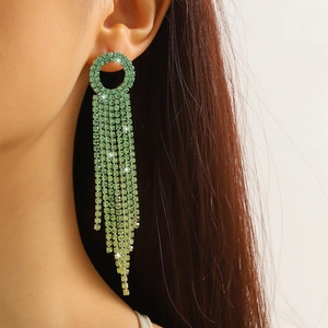 Close-up of long green rhinestone tassel earrings showing intricate drapes and shimmer
