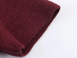 Detail shot of the burgundy knitted fabric texture and fine faux fur trim on the sleeve
