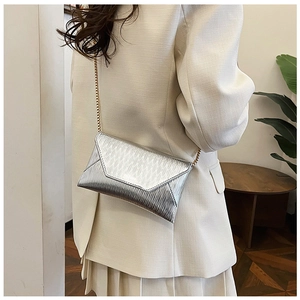 Pochette enveloppe argentée à texture métallique et chaîne dorée en cadre décontracté