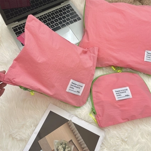 Detailed view of pink nylon travel organizers with neon green zippers and white labels
