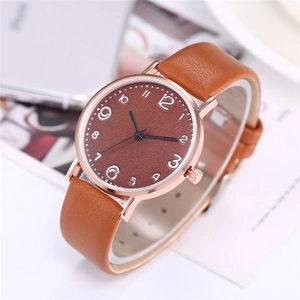 Detailed close-up of brown leather strap and rose gold quartz watch case