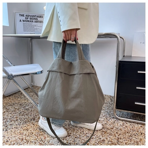 Detailed view of army green nylon tote bag held by a model in a modern office setting