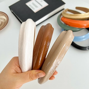 Close-up of stacked colorful sponge headbands with textured faux leather finish in various colors