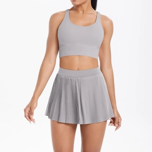Detail of light grey cross-back sports bra and pleated tennis skirt set for women