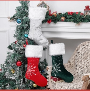 Velvet Christmas stockings with snowflake embroidery hanging on a festive mantelpiece