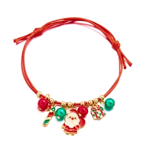Detail of handmade red woven Christmas bracelet with Santa and candy cane charms