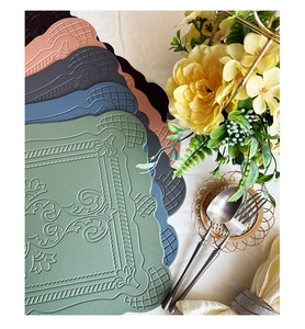 Close-up of heat-resistant faux leather placemats with vintage floral embossed patterns