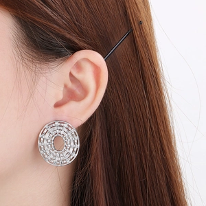 Macro view of woven hollow oval earrings in silver stainless steel on model