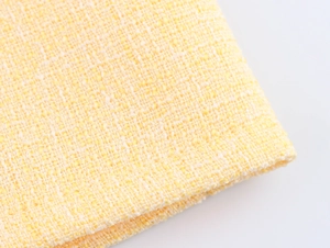 Vista macro del tessuto tweed giallo con trama a griglia intrecciata dettagliata