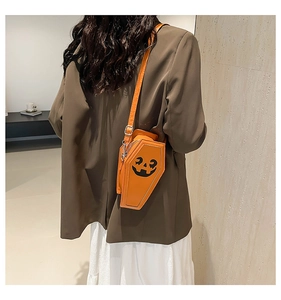 Back view of model wearing an orange coffin-shaped pumpkin crossbody bag in PU leather